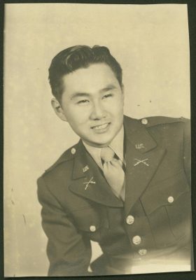 Black and white photograph of a young Asian American man in military uniform.